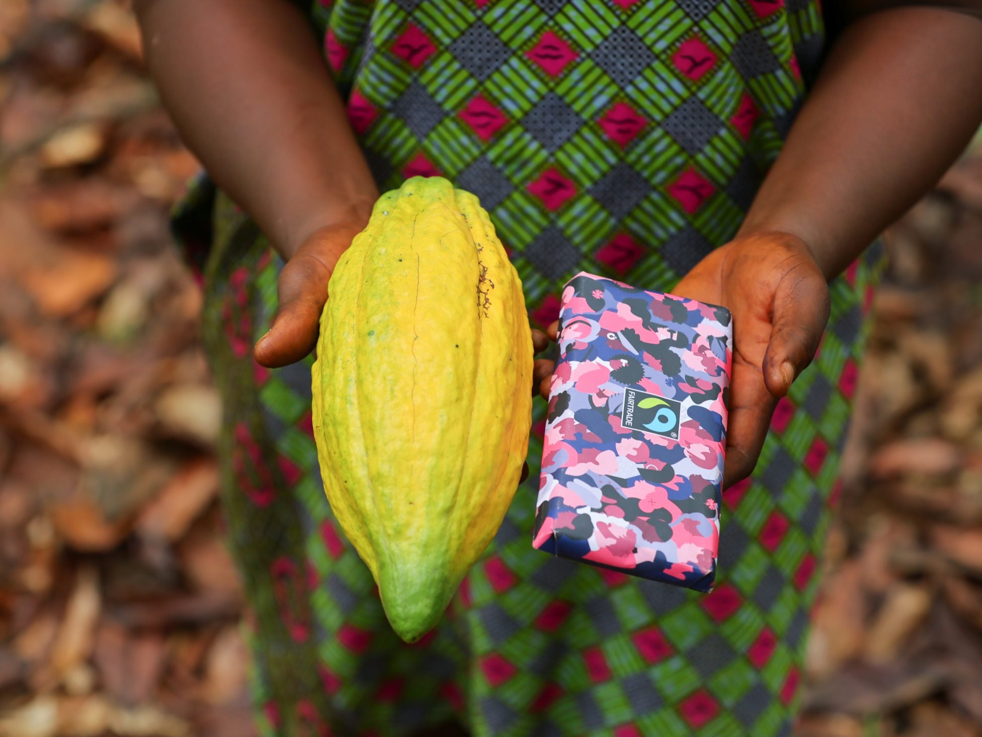 Dora Atiiga, Kakaobäuerin aus Ghana, zeigt Kakaoschote und Schokolade. © Foto: Fairtrade Nipah Dennis